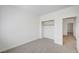 A bedroom with neutral carpet, a standard closet, and an open doorway to another area, providing simplicity at 301 Lakewood Garden Dr, Las Vegas, NV 89148