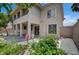 The home features a stucco exterior, balcony, and a lush backyard with mature landscaping and beautiful flowers at 301 Lakewood Garden Dr, Las Vegas, NV 89148