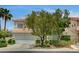 Exterior view of home showcasing desert landscaping and two-car garage at 301 Lakewood Garden Dr, Las Vegas, NV 89148