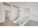 Upstairs landing and staircase with white railings and neutral carpet leading to bedrooms and other spaces at 301 Lakewood Garden Dr, Las Vegas, NV 89148