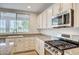 Bright kitchen features granite countertops, stainless appliances and a view of palms and mountains at 301 Lakewood Garden Dr, Las Vegas, NV 89148