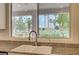 Kitchen sink with granite countertops offers a view of palms, golf course, and desert mountains at 301 Lakewood Garden Dr, Las Vegas, NV 89148