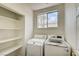 Bright laundry room with window, shelving and modern washer and dryer units at 301 Lakewood Garden Dr, Las Vegas, NV 89148