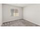 This is a neutral bedroom with gray carpet and a bright window at 330 Spring Dove Ave, Henderson, NV 89011