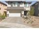Two-story home featuring a neutral color scheme with a two car garage and desert landscaping at 330 Spring Dove Ave, Henderson, NV 89011