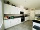 Bright kitchen with white cabinets, granite countertops, stainless steel appliances, and tile flooring at 330 Spring Dove Ave, Henderson, NV 89011