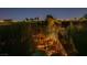 An expansive backyard view featuring a private pool, lush landscaping, and scenic city lights beyond at 3412 Crystal Tower St, Las Vegas, NV 89129