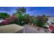 Elevated shot of backyard features a covered patio, gravel landscape, mature trees and plants at 3412 Crystal Tower St, Las Vegas, NV 89129