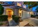 Stunning home featuring a red door, lush bushes, well-manicured lawn, and a two-car garage at twilight at 3412 Crystal Tower St, Las Vegas, NV 89129