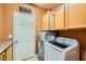 Functional laundry room featuring a washer and dryer, storage cabinets, and a door at 3412 Crystal Tower St, Las Vegas, NV 89129