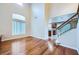 Bright living room with hardwood floors, large windows and an archway to the kitchen and stairwell, creating an open flow at 3412 Crystal Tower St, Las Vegas, NV 89129