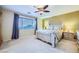 A neutral bedroom with a ceiling fan, ensuite bathroom access, and large window at 3412 Crystal Tower St, Las Vegas, NV 89129