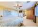 A bedroom with a large window, fan, television, and furnishings at 3412 Crystal Tower St, Las Vegas, NV 89129