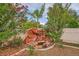 Landscaped rock waterfall feature in the backyard with lush greenery at 3412 Crystal Tower St, Las Vegas, NV 89129