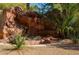Outdoor rock water feature with red flowers and green plants adds a relaxing vibe to the backyard at 3412 Crystal Tower St, Las Vegas, NV 89129