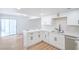 Open kitchen with white cabinets, stainless appliances, light countertops, and wood-look flooring at 3459 One Nation Ave, Las Vegas, NV 89121
