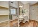 Bathroom featuring double sinks, white cabinets, wood-look floors, soaking tub, and glass-enclosed shower at 3618 Auckland Castle St, Las Vegas, NV 89135