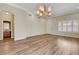 Open floor plan with wood-look flooring, neutral paint, and decorative chandelier lighting at 3618 Auckland Castle St, Las Vegas, NV 89135