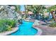 Resort-style pool area featuring lush landscaping, a waterfall, and lounge chairs at 4200 S Valley View Blvd # 2081, Las Vegas, NV 89103
