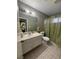 Bathroom features an olive-green wall, a vanity with a large mirror, and a shower with an olive-green shower curtain at 445 Sam Jonas Dr, Las Vegas, NV 89145