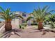 Inviting two-story home featuring desert landscaping with rocks, mature palm trees, and well-manicured shrubbery at 4693 Mill Valley Dr, Las Vegas, NV 89120