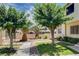 Attractive exterior view of a home featuring mature trees, desert landscaping, and a well-maintained walkway at 4693 Mill Valley Dr, Las Vegas, NV 89120
