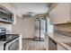 Well-lit kitchen showcasing stainless steel appliances, granite countertops, and wood-look floors at 4693 Mill Valley Dr, Las Vegas, NV 89120