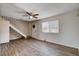Bright living room featuring wood-look flooring, a ceiling fan, and a staircase leading to the upper level at 4693 Mill Valley Dr, Las Vegas, NV 89120