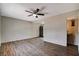 Open-concept living room featuring wood-look floors, a ceiling fan, and an easy access to the bathroom and kitchen at 4693 Mill Valley Dr, Las Vegas, NV 89120