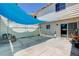 Back patio with a blue sunshade, concrete flooring, and sliding glass doors at 4693 Mill Valley Dr, Las Vegas, NV 89120