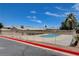 Community pool surrounded by a secure fence and lush landscaping at 4693 Mill Valley Dr, Las Vegas, NV 89120