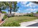 Lush backyard featuring a green lawn, mature trees, and a block wall for privacy at 471 Fallwood Ln, Las Vegas, NV 89107