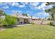 Large backyard with a covered patio, well-manicured lawn, and mature trees at 471 Fallwood Ln, Las Vegas, NV 89107