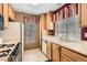 Kitchen with appliances, wood cabinets, and double basin sink at 4718 Nara Vista Way # 104, Las Vegas, NV 89103