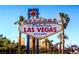 Iconic Welcome to Las Vegas sign framed by palm trees against a clear blue sky at 4718 Nara Vista Way # 104, Las Vegas, NV 89103