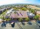 View of community center featuring a tile roof, parking, palm trees, and nearby residential buildings at 5185 Indian River Dr # 223, Las Vegas, NV 89103