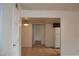 Hallway featuring tile floors leading to kitchen with white appliances, white walls, and white trim at 5185 Indian River Dr # 223, Las Vegas, NV 89103