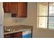 Kitchen featuring stainless steel sink, wood cabinets, and granite counters at 5185 Indian River Dr # 223, Las Vegas, NV 89103