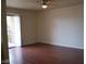 Bright, empty living room with wood floors, a ceiling fan, and a sliding door to the balcony at 5185 Indian River Dr # 223, Las Vegas, NV 89103