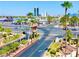 Street view of Bella Vita condos with palm trees and landscaping in the foreground, city buildings in the background at 5185 Indian River Dr # 223, Las Vegas, NV 89103