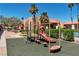 Community playground with a slide and other play structures amidst landscaping at 5185 Indian River Dr # 223, Las Vegas, NV 89103