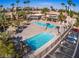 Aerial view of a community pool featuring lounge chairs, palm trees, and a clubhouse at 5185 Indian River Dr # 223, Las Vegas, NV 89103