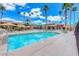 Community swimming pool with clear blue water, lounge seating, and surrounding palm trees, perfect for relaxation and recreation at 5185 Indian River Dr # 223, Las Vegas, NV 89103