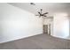 A bright bedroom features neutral carpet, a ceiling fan, and an ensuite bathroom at 5321 Marietta Ave, Las Vegas, NV 89108