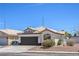 Exterior of a single-story home, featuring desert landscaping, a tile roof, and a dark brown garage door at 5321 Marietta Ave, Las Vegas, NV 89108