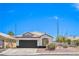 Charming home featuring a brown garage door, tile roof, desert landscaping, and a large window at 5321 Marietta Ave, Las Vegas, NV 89108