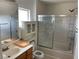 Bathroom with cabinet, toilet, sink, decorative glass shower-tub combo and a large mirror at 5334 Floating Flower Ave, Las Vegas, NV 89139