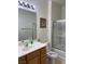 Bright bathroom features wood vanity, shower/tub combo with sliding glass door at 5334 Floating Flower Ave, Las Vegas, NV 89139