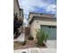 Exterior view of a home featuring a green garage door, neatly landscaped yard, and a view of adjacent houses at 5334 Floating Flower Ave, Las Vegas, NV 89139