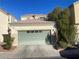 Home exterior featuring a sage green garage door and desert landscaping at 5334 Floating Flower Ave, Las Vegas, NV 89139